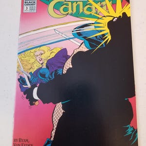 Może przedstawiać: Okładka komiksu Black Canary #3, z dynamiczną ilustracją. Grafika przedstawia blondwłosą kobietę w fioletowym stroju walczącą z czarną postacią. Tytuł jest ż&oacute;łty i zielony, na r&oacute;żowym i czarnym tle.