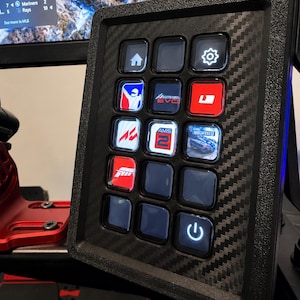 May include: A black button panel with a carbon fiber texture. The panel has 12 illuminated buttons with various icons and logos, including a house, gear, and power symbol. The panel is likely for a racing simulator.