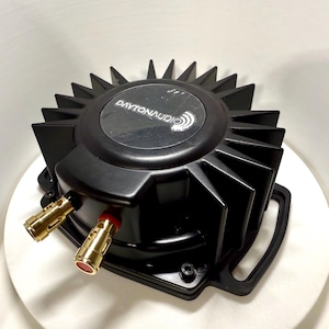 May include: Black Dayton Audio speaker component with a heat sink design. The component has gold-colored connectors and a black plastic frame. The Dayton Audio logo is visible on the top of the component.