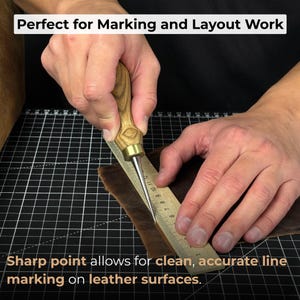 May include: A leather marking tool with a wooden handle and a sharp metal point is used with a ruler on a piece of brown leather. The text "Perfect for Marking and Layout Work" and "Sharp point allows for clean, accurate line marking on leather surfaces" are visible.
