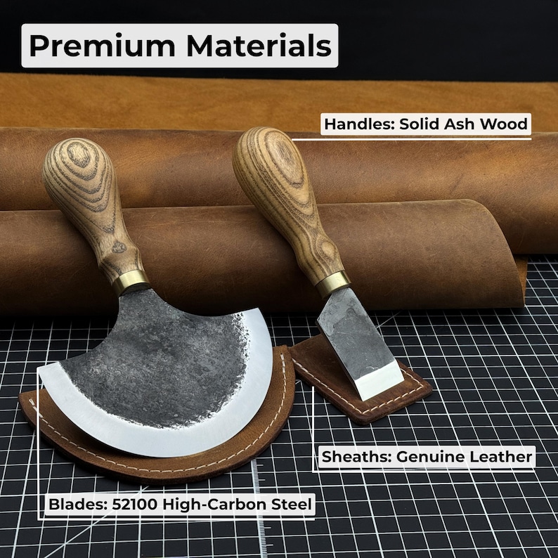 Puede incluir: Dos cuchillos para trabajar el cuero con mangos de madera maciza de fresno y hojas de acero con alto contenido de carbono 52100. Las hojas est&aacute;n colocadas en fundas de cuero genuino. El texto "Premium Materials" est&aacute; en la parte superior.