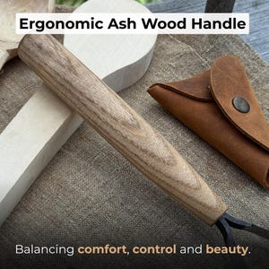 May include: Close-up of a woodworking tool with an ergonomic ash wood handle. The handle is light brown with wood grain. The text "Ergonomic Ash Wood Handle" is at the top. The text "Balancing comfort, control and beauty" is at the bottom.