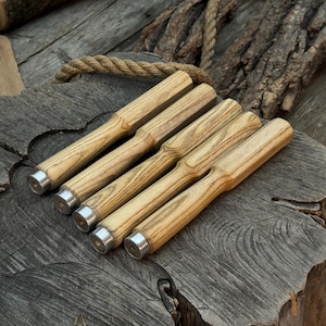 以下が含まれることがあります： 明るい茶色の仕上げと銀色の金属端を持つ5つの木製ツールセット。ツールは、デザインと職人技を強調するために、木製のテクスチャ表面に斜めに配置されています。木工用のツールである可能性があります。