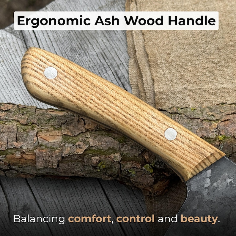 Puede incluir: Primer plano de un mango de cuchillo de madera de fresno. El mango es de color marr&oacute;n claro con un patr&oacute;n de vetas de madera y dos remaches plateados. El texto "Ergonomic Ash Wood Handle" est&aacute; en la parte superior y "Balancing comfort, control and beauty" en la inferior.