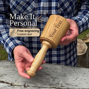May include: A wooden mallet with a cylindrical head and a tapered handle. The head features the engraved text "Your Text". The image includes overlay text that reads "Make It Personal" and "Free engraving Custom text" with a pencil icon.