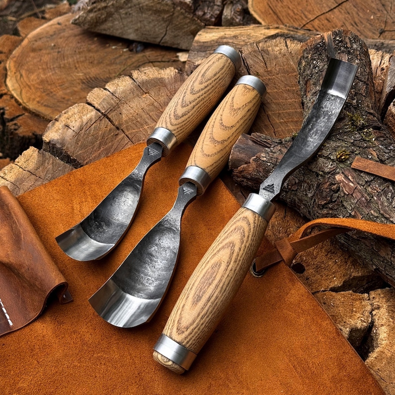 Puede incluir: Tres gubias para madera con hojas met&aacute;licas curvas y mangos de madera clara. Cada herramienta cuenta con una virola de metal que conecta el mango con la hoja de acero, la cual presenta un acabado oscuro y texturizado con un peque&ntilde;o logotipo.