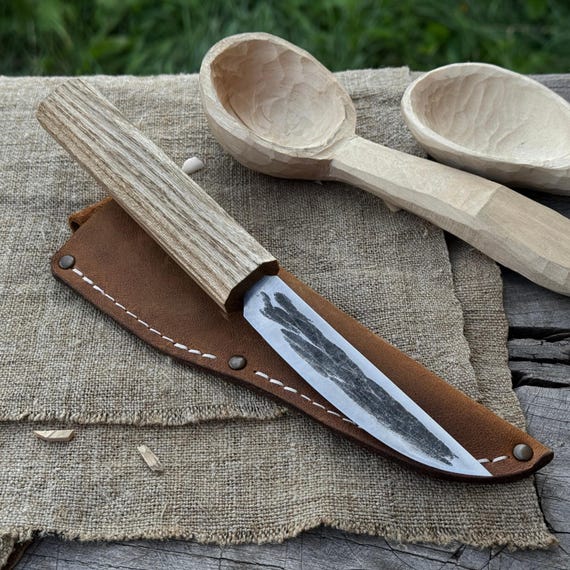 A hand-forged Yakutian-style carbon steel blade with ash handle and leather sheath — traditional Siberian knife design rarely seen outside specialist circles, 121 favorites validates real demand.