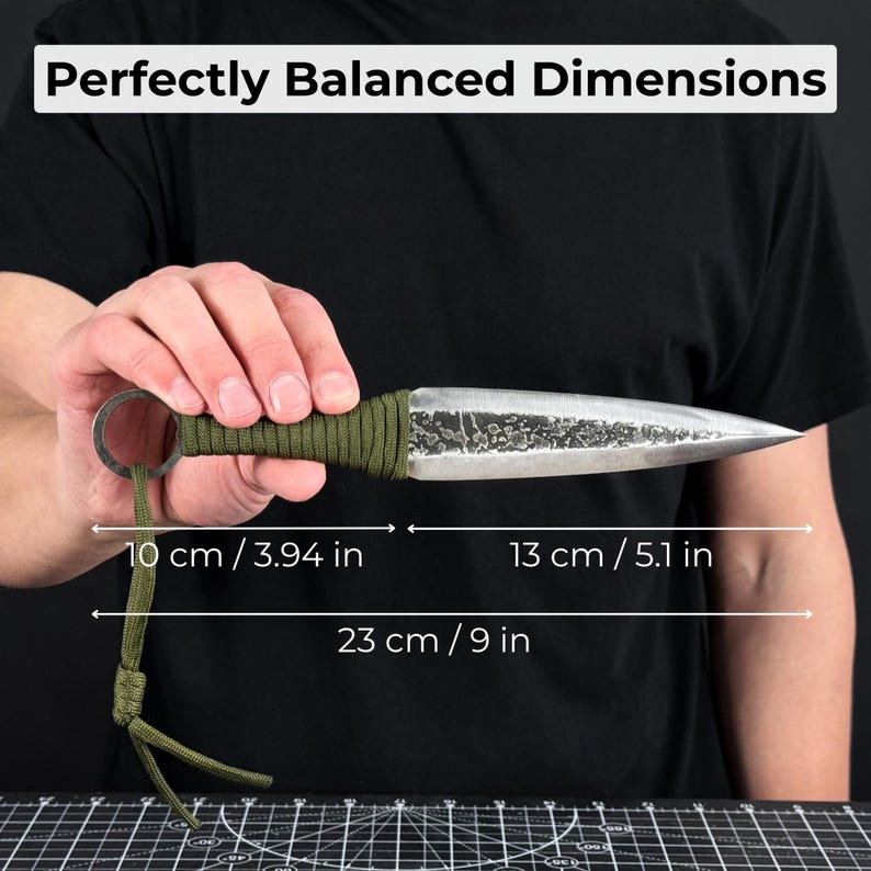 K&ouml;nnte beinhalten: Ein handgeschmiedetes Messer mit strukturierter Klinge und gr&uuml;n umwickeltem Griff. Der Text "Perfectly Balanced Dimensions" steht oben. Das Messer ist 23 cm lang, mit einer 13 cm Klinge und einem 10 cm Griff.