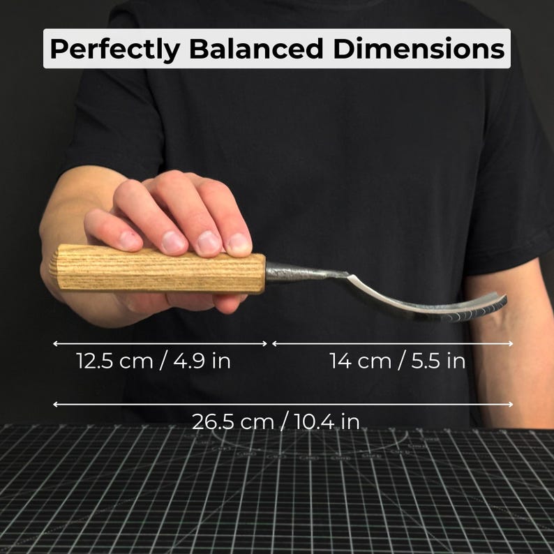 May include: A wood-handled carving knife with a curved blade. The text "Perfectly Balanced Dimensions" is at the top. The knife is 12.5 cm (4.9 in) long, the blade is 14 cm (5.5 in), and the total length is 26.5 cm (10.4 in).