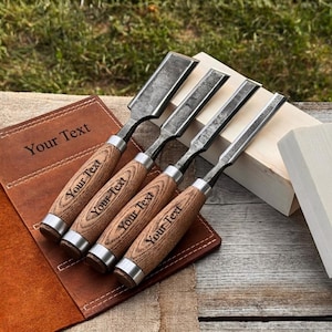 Peut inclure: Un ensemble de quatre ciseaux à bois avec des lames en métal sombre et des manches en bois brun clair, chacun portant le texte gravé Your Text. Les ciseaux sont disposés sur un étui en cuir brun avec le texte Your Text gravé sur le cuir.
