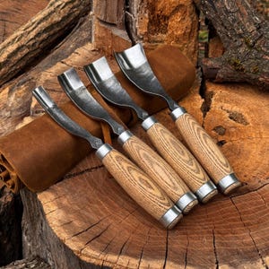 Pu&ograve; includere: Un set di quattro sgorbie per intaglio con lame metalliche curve e manici in legno chiaro con un distinto motivo a venature. Ogni utensile presenta una ghiera in metallo argentato che collega la lama al manico e un piccolo logo impresso.
