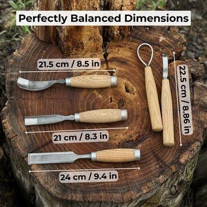 Pode incluir: Um conjunto de ferramentas de entalhe em madeira com cabos de madeira e l&acirc;minas de metal, exibidas em um tronco de &aacute;rvore. A imagem inclui medidas: 21,5 cm, 21 cm, 24 cm e 22,5 cm. O texto "Perfectly Balanced Dimensions" est&aacute; no topo.