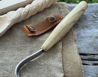 Cuchillo de gancho largo para tallar cucharas. Hoja afilada. Forjado a mano en acero al carbono 52100 endurecido, mango ergonómico de fresno y funda de cuero.