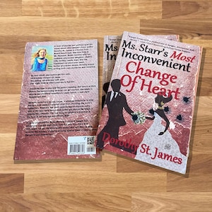 May include: Two paperback books with red, white, and black covers. The front cover of the book on top features a silhouette of a couple in wedding attire. The title of the book is "Ms. Starr's Most Inconvenient Change of Heart" by Dorothy St. James. The back cover of the book on the bottom features a woman in a blue shirt and a white background. The text on the back cover reads "A lover of puzzles and perhaps a bit too messy about other people's lives..."