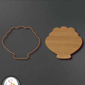 May include: A wooden cutout of a clam shell. The clam shell is shown in two views: a solid outline and a filled-in shape. The cutout is perfect for crafting projects.