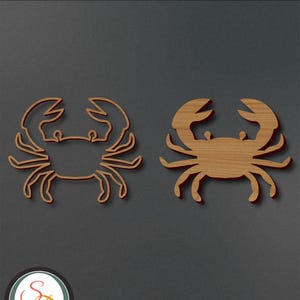 May include: Two wooden cutout designs of a crab. The crab on the left is an outline, while the crab on the right is a solid shape.