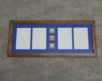 May include: A wooden picture frame with a blue mat and four white openings. The frame has three small colorful squares with text that reads "Happy Life" and "Celebrate".