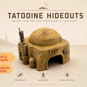 Könnte beinhalten: Ein beigefarbener, kuppelförmiger Wüstenunterstand für Terrarien und Tabletop-Spiele. Das Objekt hat eine texturierte Oberfläche, einen zentralen Bogeneingang und einen vertikalen zylindrischen Anbau links. Text: TATOOINE HIDEOUTS.