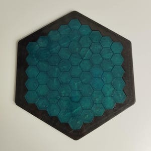 May include: A hexagonal wooden game board with a teal blue honeycomb pattern.