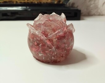 Op de afbeelding: Een roze en heldere glazen rozen sculptuur met een textuur.