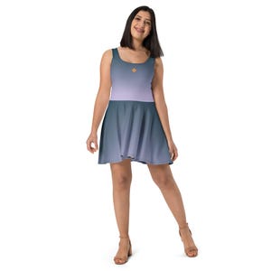 May include: A sleeveless skater dress with a gradient design in shades of purple and blue. The dress has a small, gold diamond-shaped design on the bodice.