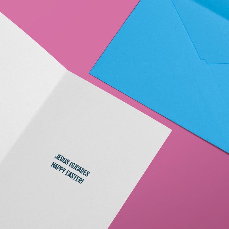 Op de afbeelding: Een witte kaart met een blauwe envelop. De kaart heeft de tekst "Jesus (sic)cares. Happy Easter!" gedrukt aan de binnenkant.