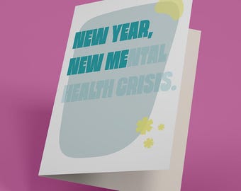 May include: A white greeting card with the text "NEW YEAR, NEW MENTAL HEALTH CRISIS" in teal and light blue. The card has a light blue and white design with yellow accents on a pink background.