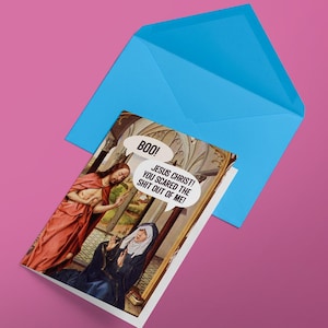 Op de afbeelding: Een humoristische kaart met een schilderij van Jezus en een vrouw. De vrouw kijkt verbaasd en de tekstballon zegt "Boo! Jezus Christus! Je hebt me de schrik van mijn leven gegeven!"