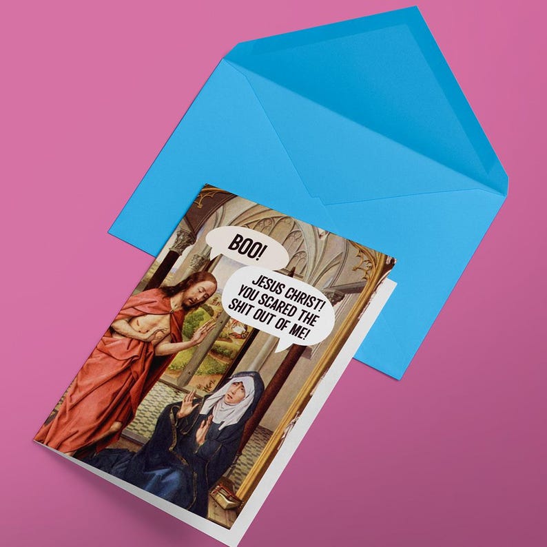 Op de afbeelding: Een humoristische kaart met een schilderij van Jezus en een vrouw. De vrouw kijkt verbaasd en de tekstballon zegt "Boo! Jezus Christus! Je hebt me de schrik van mijn leven gegeven!"
