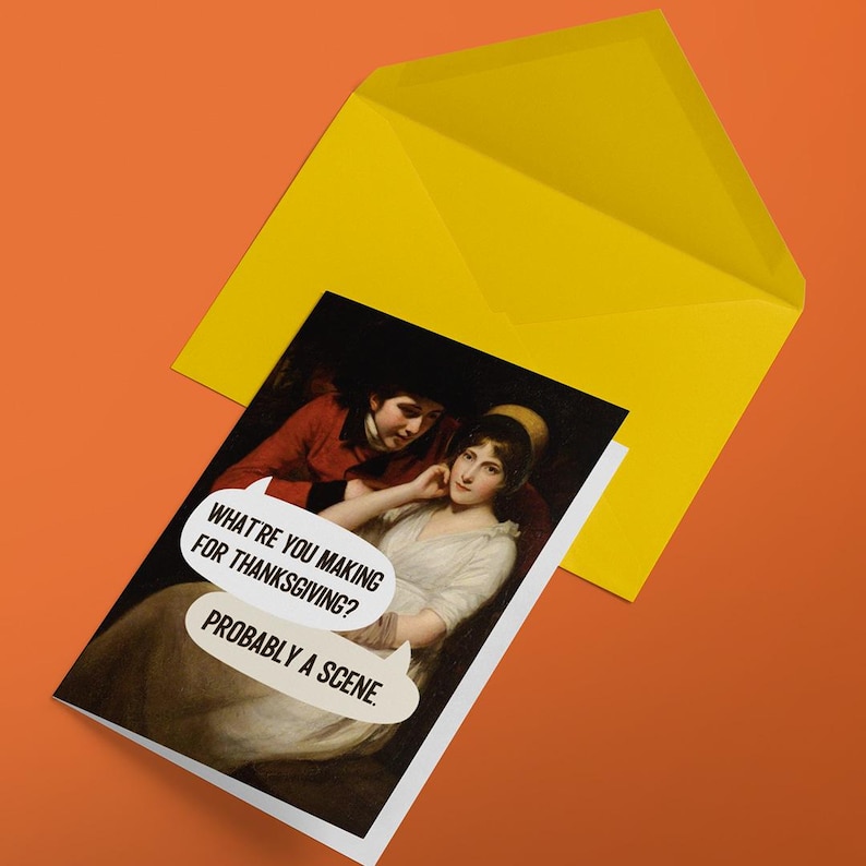 Puede incluir: Una tarjeta de felicitaci&oacute;n con una pintura cl&aacute;sica de dos figuras con globos de texto que dicen: WHAT'RE YOU MAKING FOR THANKSGIVING? PROBABLY A SCENE. La tarjeta est&aacute; parcialmente insertada en un sobre amarillo brillante sobre un fondo naranja.