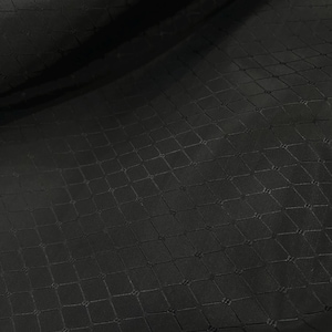 May include: Black fabric with a textured diamond pattern.