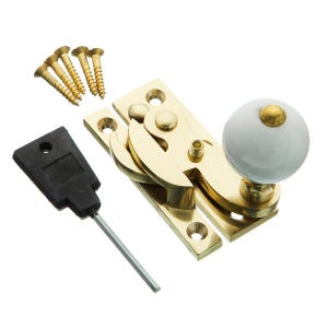 May include: Brass window latch with a white ceramic knob and a black plastic tool. The latch has a spring-loaded mechanism and is designed to secure windows.