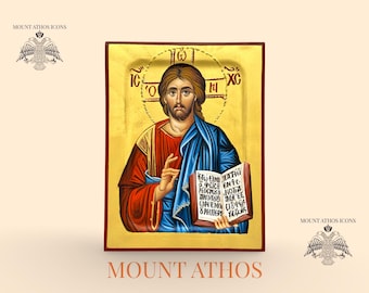 May include: Hand-painted icon featuring a religious figure with a halo, holding a book. The figure is depicted in red and blue robes against a gold background. The icon has text in Greek and is framed in a brown wooden border. The text "MOUNT ATHOS" is at the bottom.