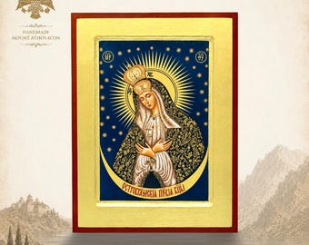 May include: A rectangular religious icon featuring a central figure wearing a crown and dark patterned mantle against a deep blue background with gold stars and a crescent moon. The text OСТРОБРАМСКАЯ ПРЕСВ БЦЫ is printed at the bottom.