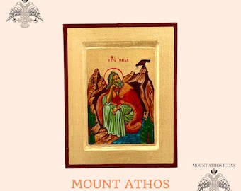 May include: Hand-painted icon of Saint John the Baptist, depicted in a mountainous landscape. The icon is framed in gold and red wood. The text "Ο ΑΓΙΟΣ ΙΩΑΝΝΗΣ" is written in Greek at the top of the icon.