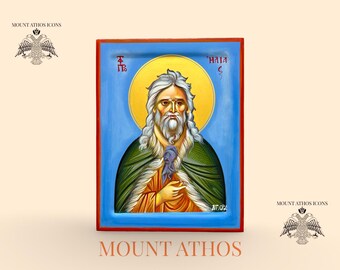 May include: Hand-painted icon of a man with a long white beard and hair, wearing a green cloak and holding a scroll. The icon has a blue background with a gold halo. The text "MOUNT ATHOS" and "Hand painted Icon" are at the bottom.