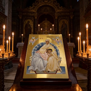 Può includere: Un'icona religiosa dorata raffigurante due figure in abiti, con aureole e ali d'angelo, posta su un supporto di legno. Candele accese affiancano l'icona, con altre candele e arte religiosa sullo sfondo. La scena è ambientata in una chiesa.