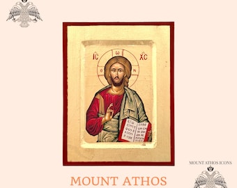 May include: A hand-painted icon of Jesus Christ, wearing a red robe and with a gold halo. The icon is framed in a wooden frame with a gold border. The text "IC XC" is written in Greek at the top of the icon.