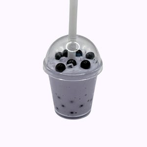 Lavender glossy slime in a clear jar labeled “Taro Boba,” topped with realistic ice cube charms, black boba ball charms, and a mini boba cup. Soft, thick texture and smooth finish, perfect for ASMR and bubble pops. Suitable for slime enthusiasts, collectors, and sensory play lovers.