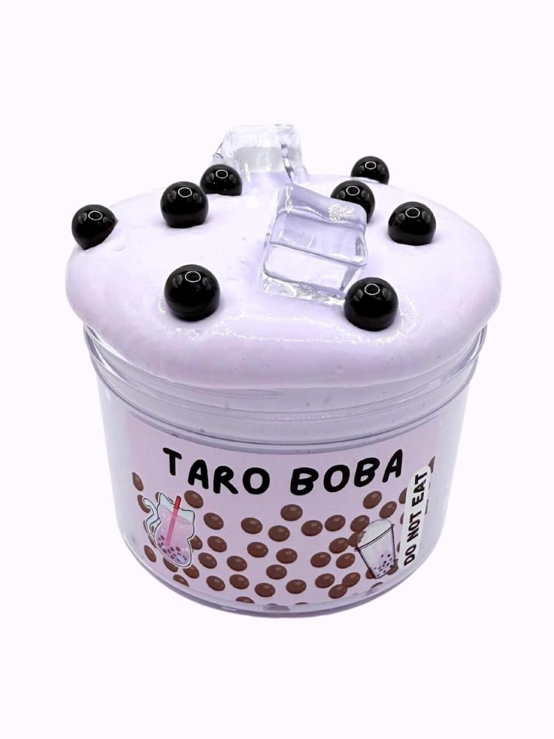 Lavender glossy slime in a clear jar labeled “Taro Boba,” topped with realistic ice cube charms, black boba ball charms, and a mini boba cup. Soft, thick texture and smooth finish, perfect for ASMR and bubble pops. Suitable for slime enthusiasts, collectors, and sensory play lovers.