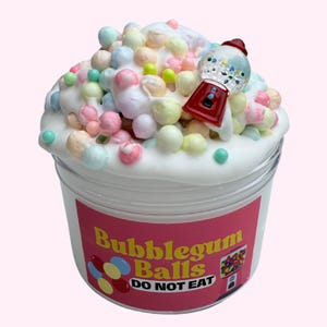 May include: A white slime with colourful foam balls and a gumball machine charm in a clear plastic container. The label reads "Bubblegum Balls DO NOT EAT".