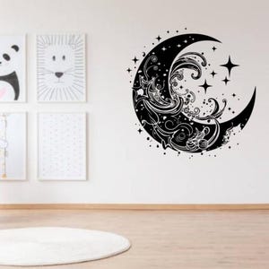 Peut inclure: Sticker mural de lune en croissant noir et blanc avec un motif tourbillonnant et des étoiles. La lune est soulignée en noir et le motif est rempli de blanc. Les étoiles sont également noires.