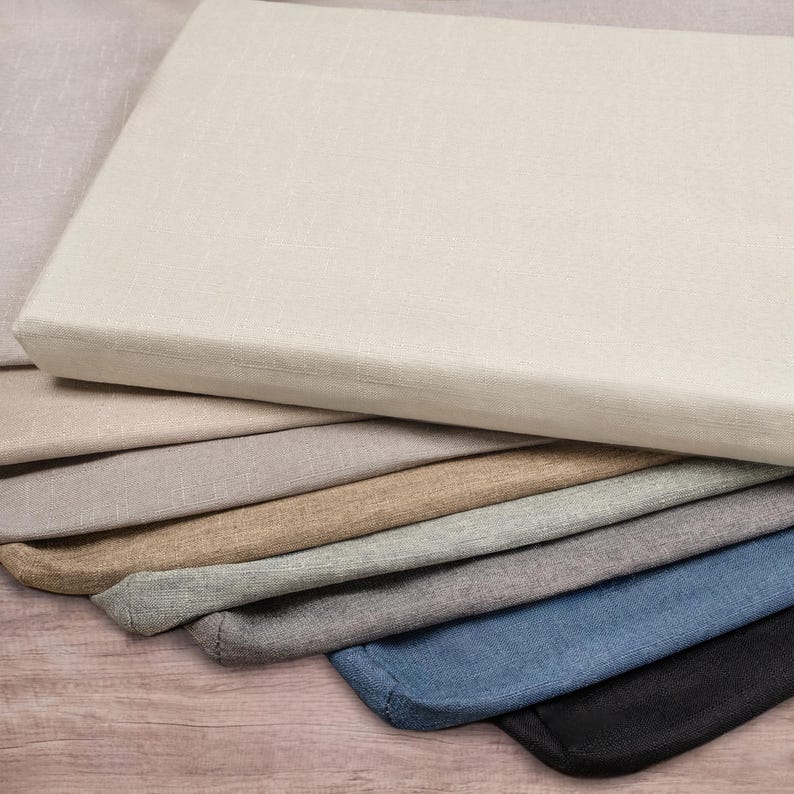 May include: A stack of fabric swatches in various shades of grey, beige, and blue. The swatches are arranged in a graduated colour scheme, with the lightest shade at the top and the darkest shade at the bottom.