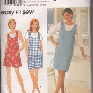 May include: A Simplicity sewing pattern envelope 7108 for a sleeveless jumper dress with a scoop neckline and side buttons. The pattern includes three variations: a short red floral dress, a short blue plaid dress, and a knee-length solid blue dress.