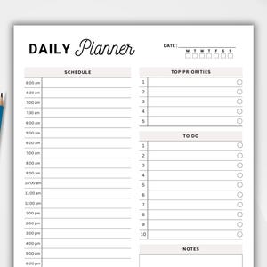 May include: A black and white daily planner with sections for schedule, top priorities, to do, and notes. The planner has a simple design with lines for writing and checkboxes for marking tasks.