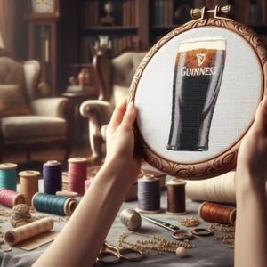 Pu&ograve; includere: Un telaio da ricamo con un punto croce di una pinta di Guinness. L'opera &egrave; tenuta in mano, con rocchetti di filo colorato, forbici e accessori da cucito su un tavolo. Lo sfondo comprende mobili antichi e una libreria.