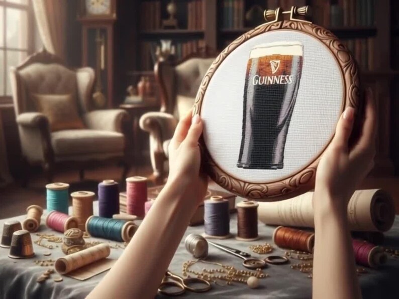 Pu&ograve; includere: Un telaio da ricamo con un punto croce di una pinta di Guinness. L'opera &egrave; tenuta in mano, con rocchetti di filo colorato, forbici e accessori da cucito su un tavolo. Lo sfondo comprende mobili antichi e una libreria.