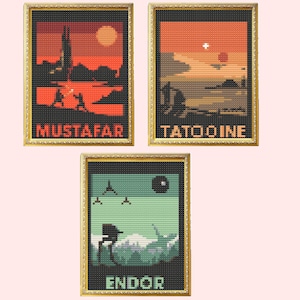 May include: Three framed cross-stitch art prints featuring scenes from Star Wars. The first print shows a red and orange sunset over a cityscape with the text "Mustafar". The second print shows a desert landscape with two suns and the text "Tatooine". The third print shows a green and blue landscape with a Death Star in the background and the text "Endor".