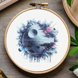 Può includere: Una tela bianca con un design astratto colorato che presenta una Morte Nera grigia di Star Wars. La Morte Nera è circondata da un design nuvoloso blu, bianco e rosa.