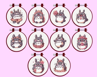 Puede incluir: Diez aros de bordado con diferentes diseños de un personaje Totoro gris con flores rosas. El personaje Totoro lleva una corona de flores, sostiene una flor o lleva un tutú rosa.